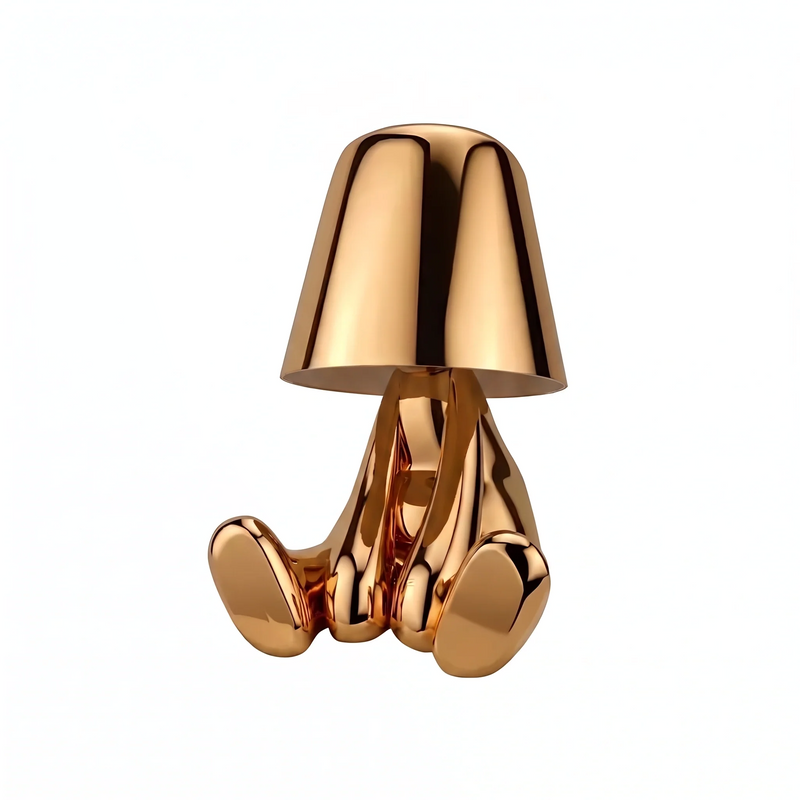 Thinker figurlampa i mässingsfärgad metall på vit bakgrund